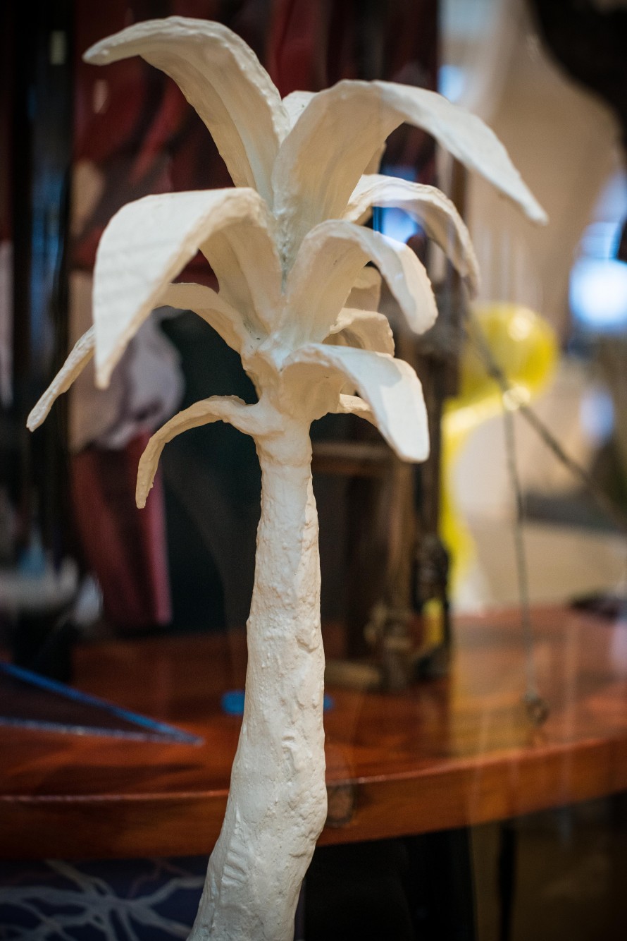 Small white sculpture of a palm tree.