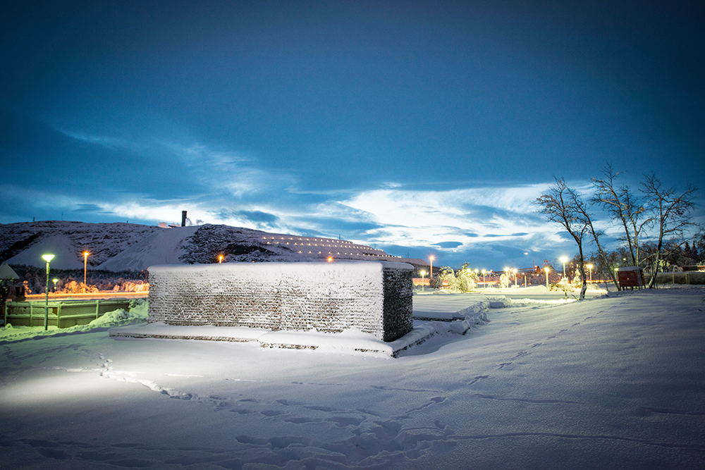 Snölandskap upplyst av gatlyktor med mörk himmel och i mitten snötäckta gabioner med rivningsmassor. Sofia Sundberg, Karl Tuikkanen, Ingo Vetter, Gruvstadsparken.