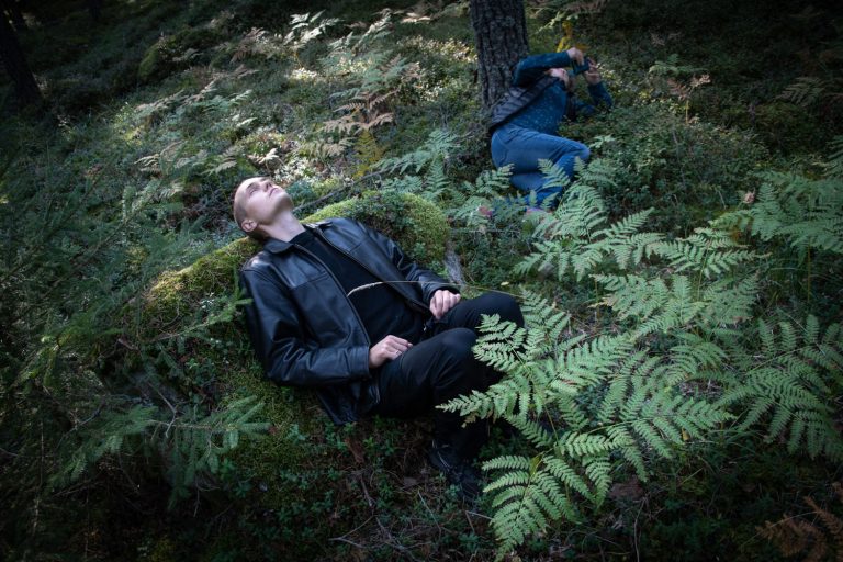 Två personer ligger i mossan