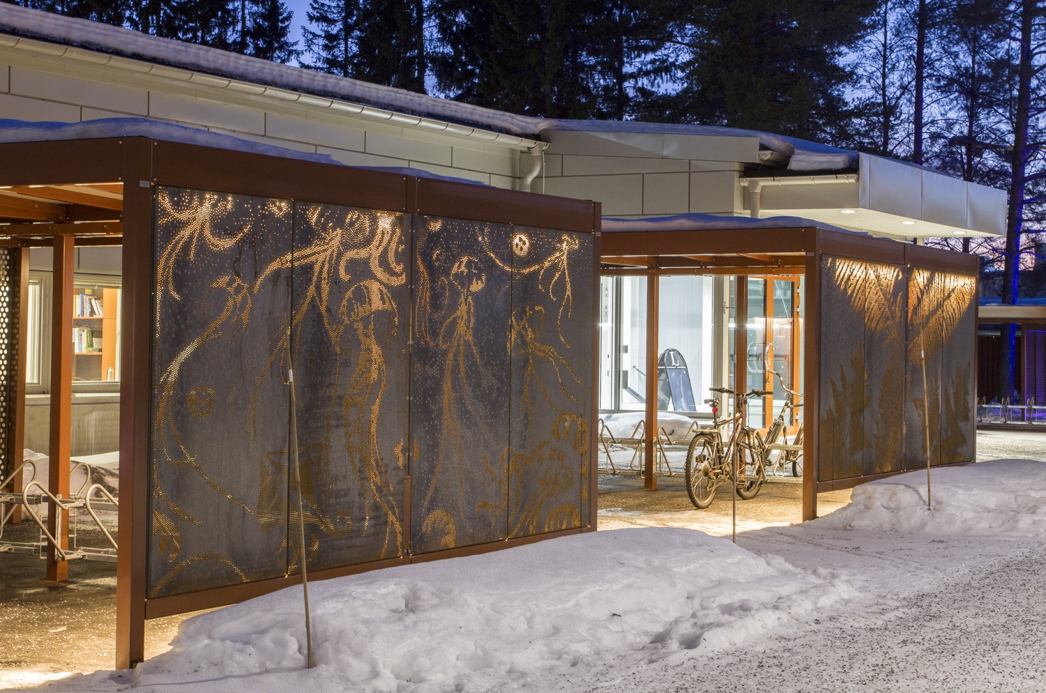 Cykelställ i skuren rostig plåt som lyser i vintermörkret