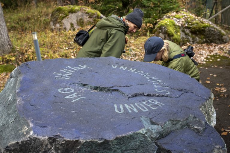En sten med graverad text. Jag väntar under stjärnorna