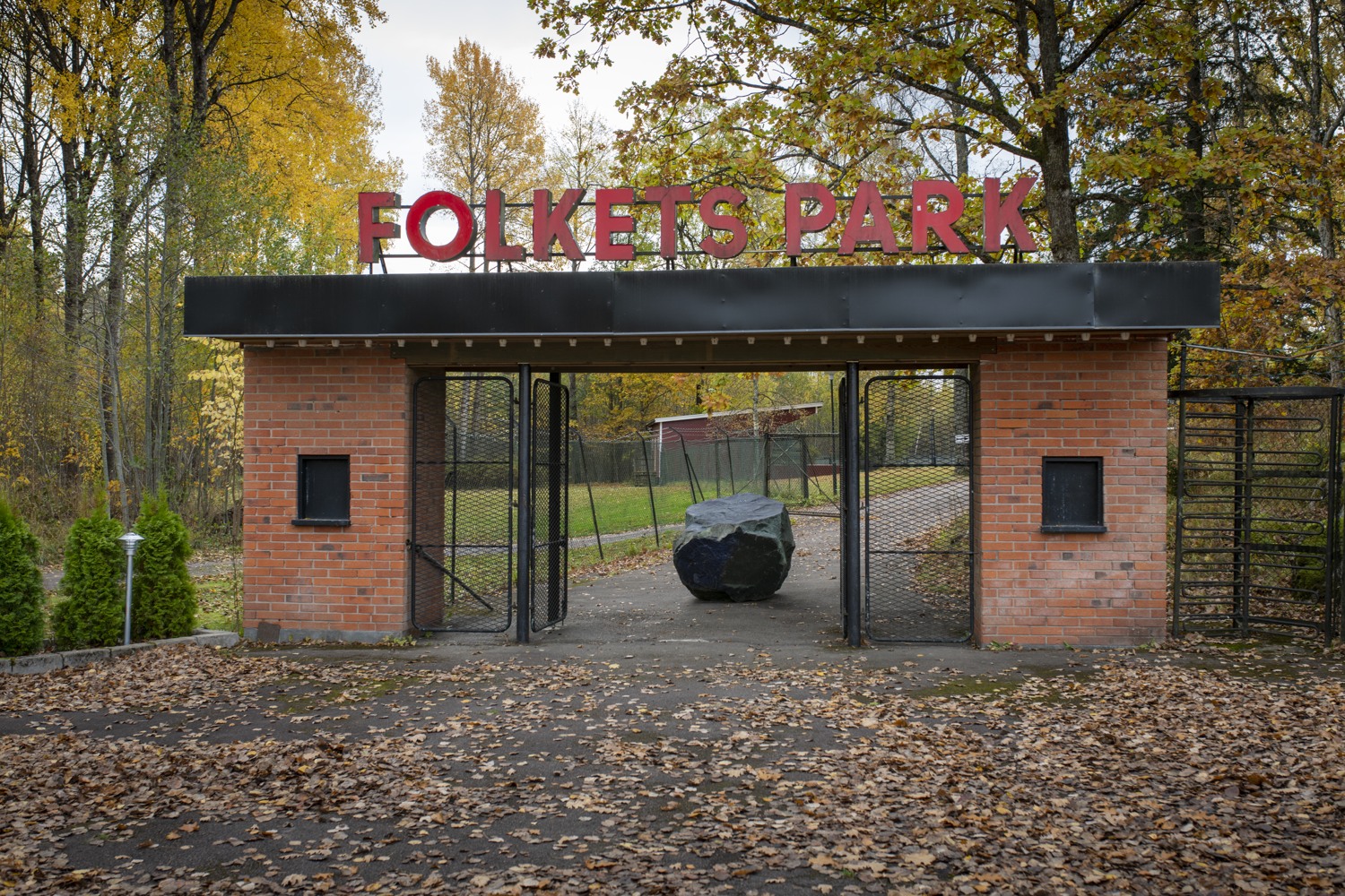 Ingång till Folkets park. En sten står i mitten av ingången