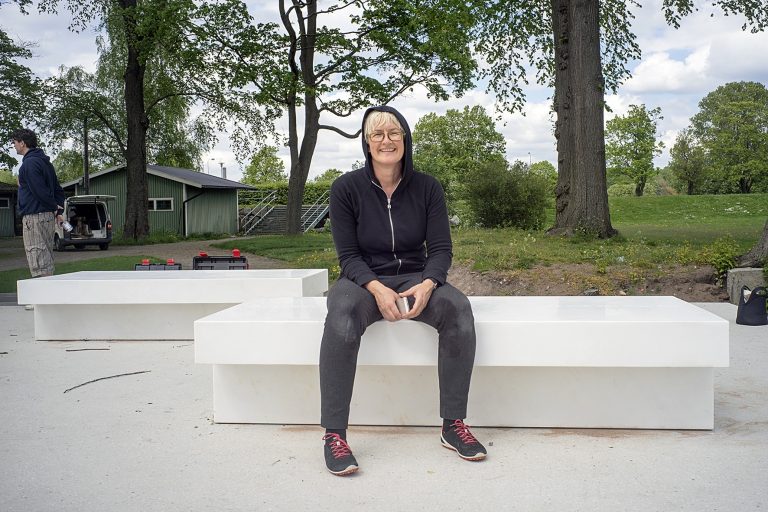 kvinna som sitter på en bänk