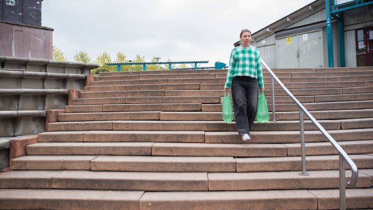 Kvinna som går ner för trappa