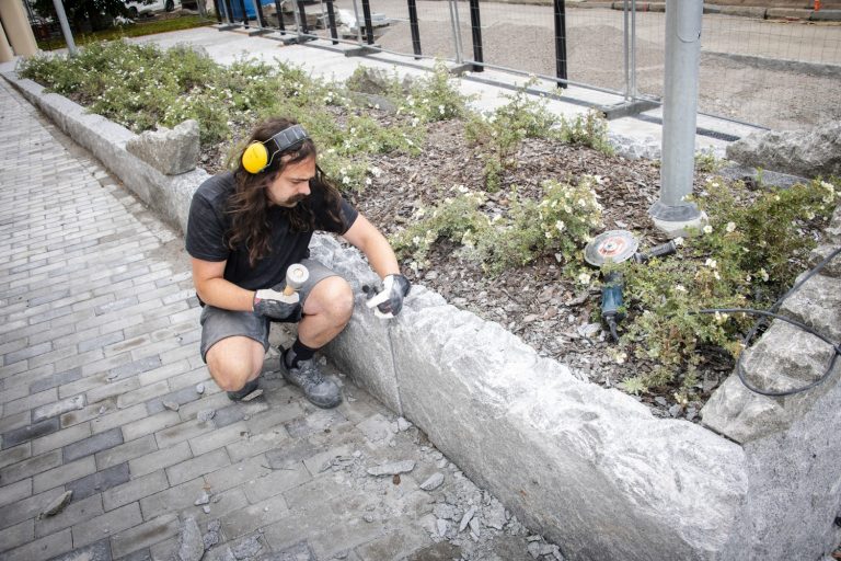 En man sitter på marken med en skateboard
