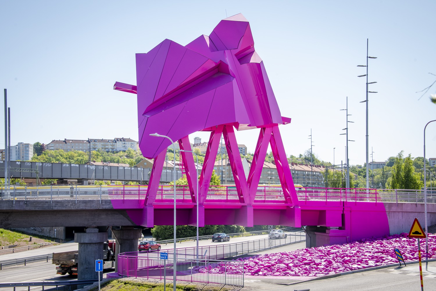 En rosa skulptur vid sidan av en motorväg.