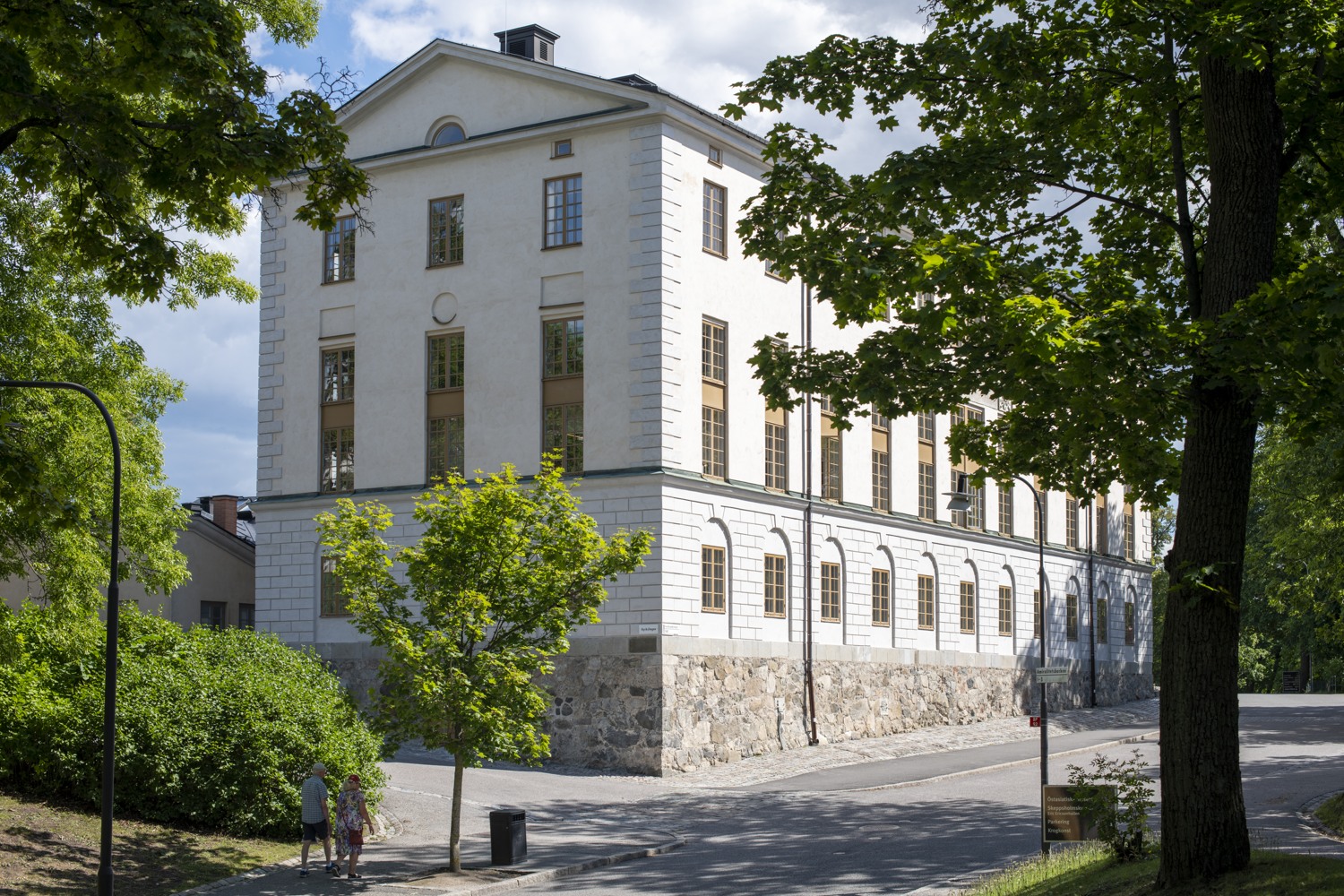 En stor vit byggnad som står vid sidan av en väg