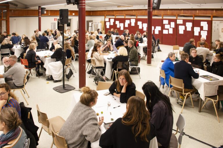 Människor sitter i grupp i en stor sal