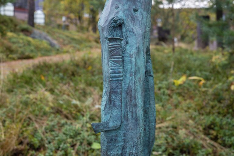 En staty av en person som håller i en träbit.